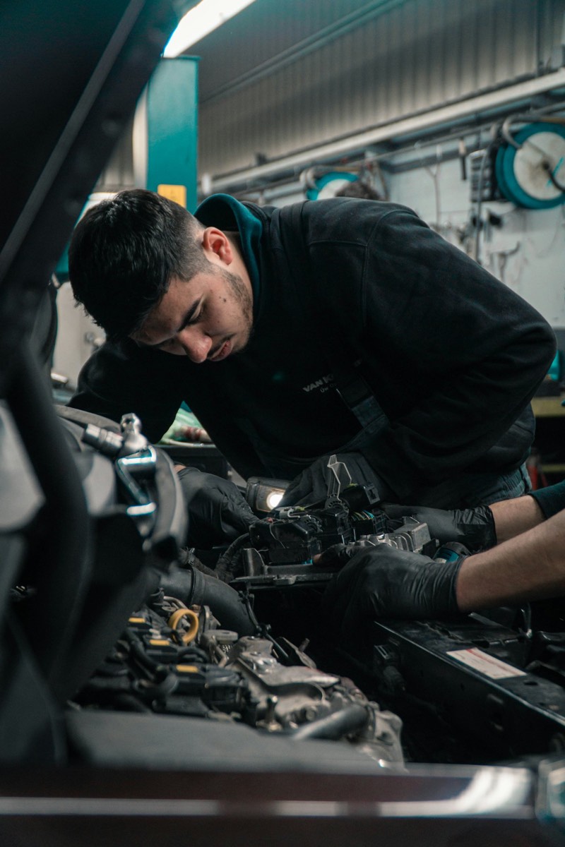Mécanicien penché sur le moteur d'une voiture