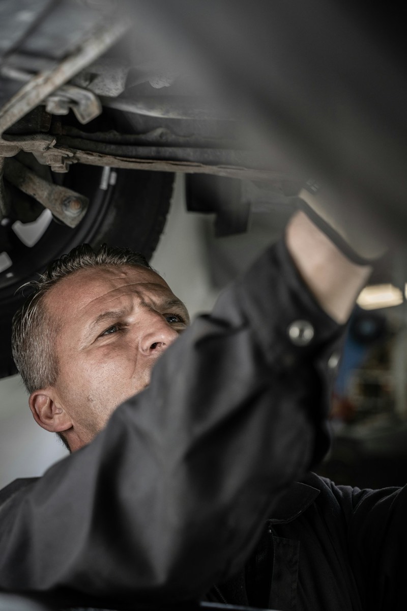 Mécanicien allongé sous une voiture pour un contrôle